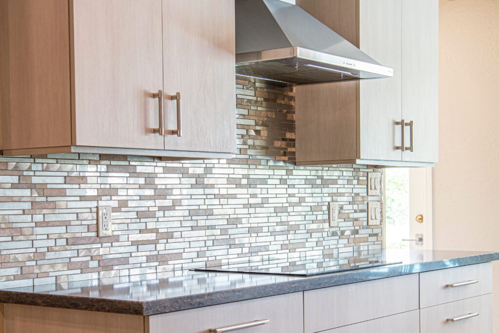 Stylish modern kitchen with elegant cabinets and custom sleek backsplash design by RNM Services in Naramata